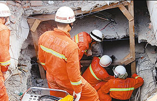 救援人員在被掩埋的樓體中探測生命跡象