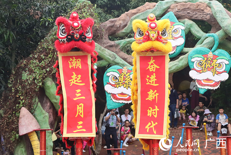 开幕式活动中，一对醒狮站在“梅花桩”上吐出“潮起三月三 奋进新时代”主题。人民网记者 彭远贺摄