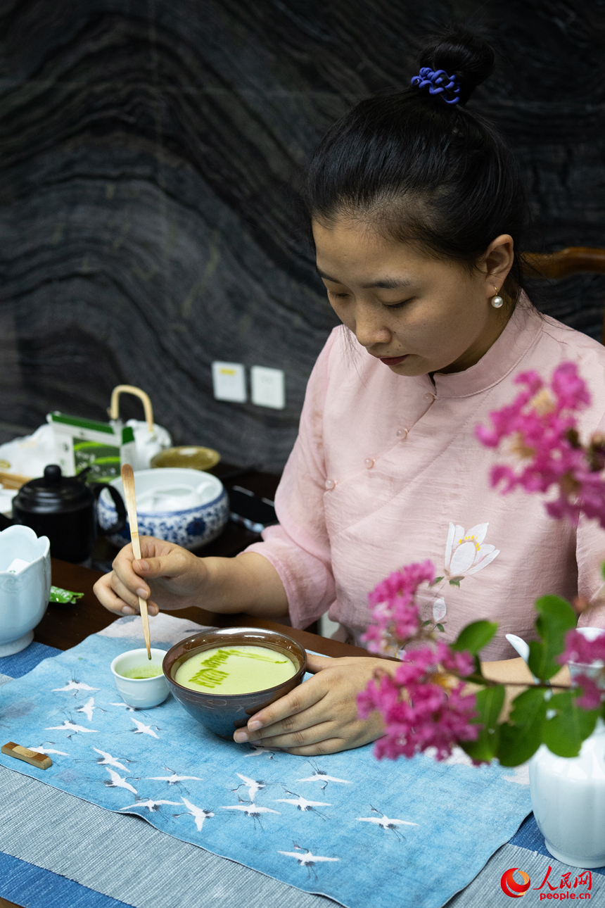 茶艺师在茶汤上作画。人民网 江佳玲摄