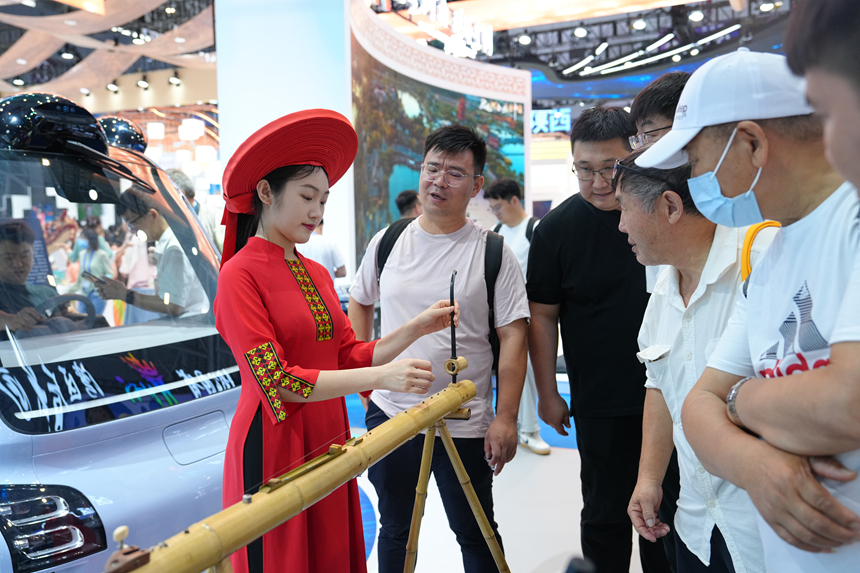 广西展区，传统乐器表演者为观众介绍乐器原理。人民网 刘森君摄
