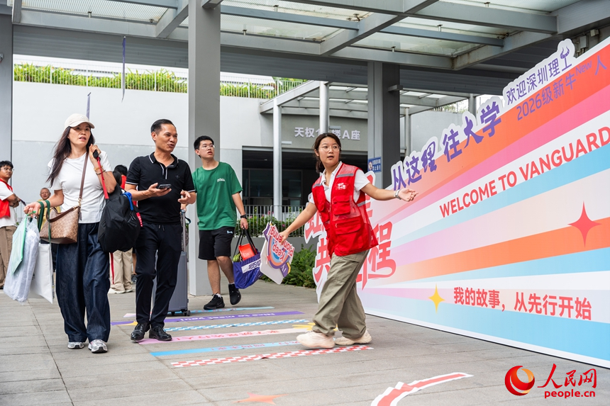 志愿者引导新生前往书院报到。人民网记者 王星摄
