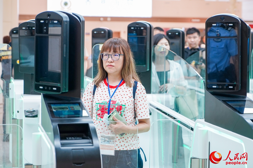 通关旅客根据设备提示核验信息。人民网记者 王星摄