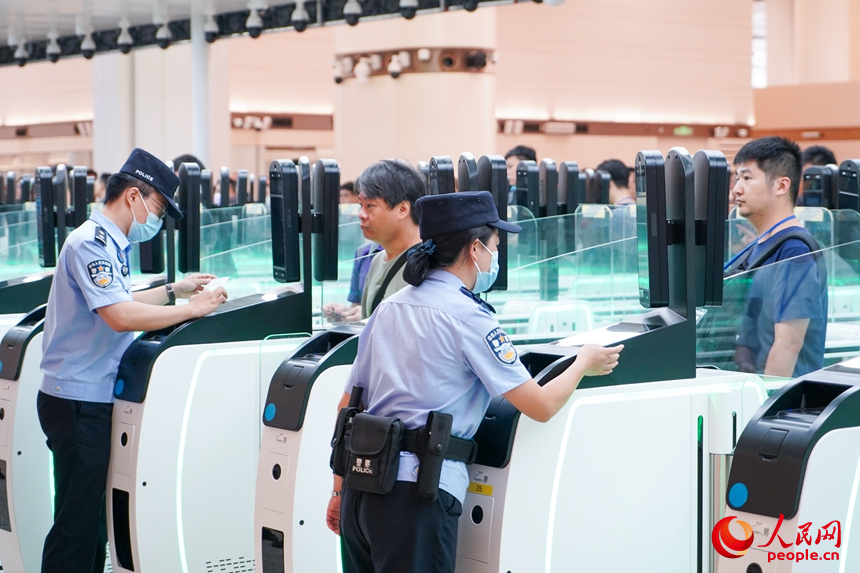 边检民警正在核对通关旅客信息。人民网记者 王星摄